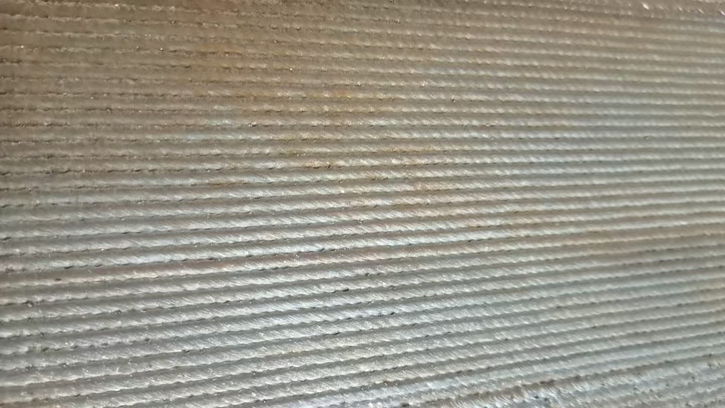 Close-up of overlapping laser wire deposition tracks before machining